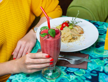 Midsection of woman holding drink