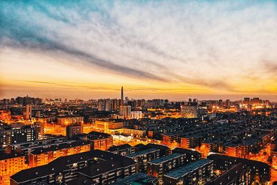 High angle view of illuminated cityscape against sky during sunset