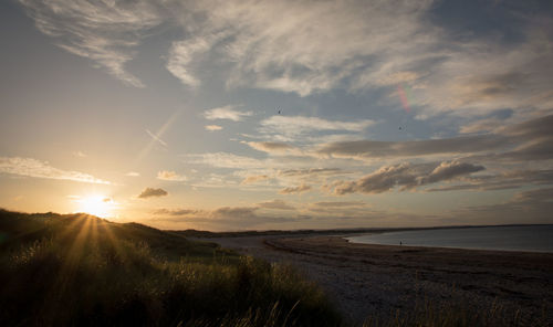 Scenic view of beach against sky during sunset