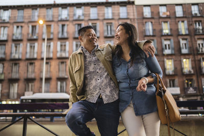 Happy mature couple in front of building spending weekend together