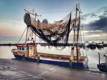 Fishing boats in harbor at sunset