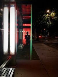 People standing on footpath at night