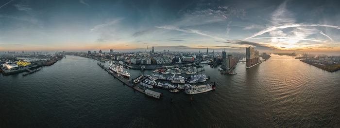 High angle view of cityscape by sea against sky during sunset