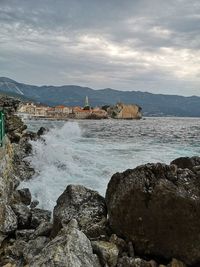Rocks by sea against sky