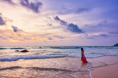 Young woman standing in sea waves. sky and sea beautiful sunset.