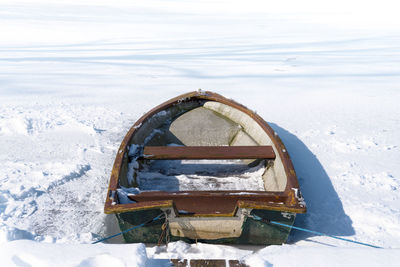 Frozen boat in winter against sky