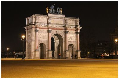 Statue in city at night