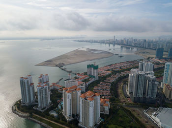 High angle view of buildings by sea against sky