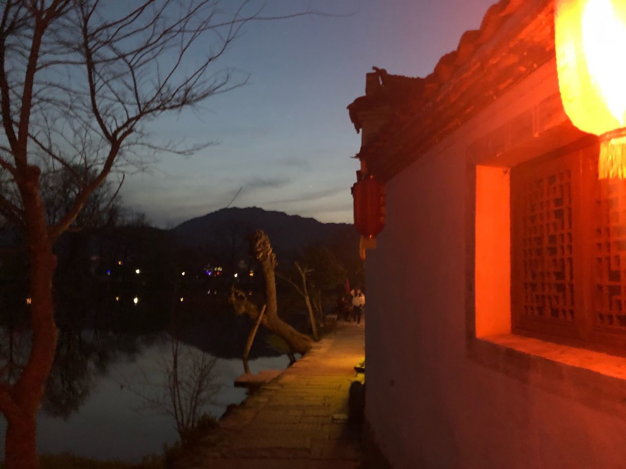 ILLUMINATED STREET AMIDST BUILDINGS AT DUSK