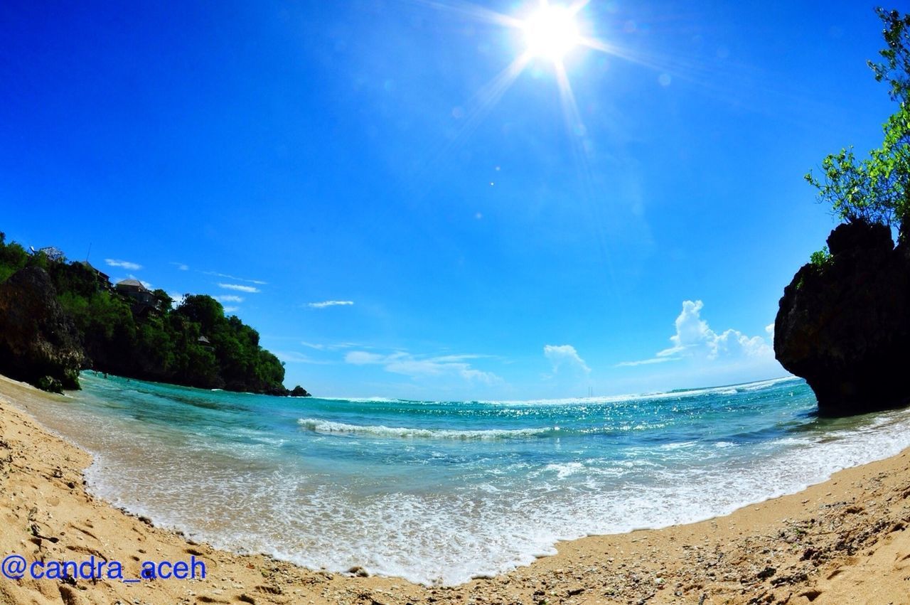 sea, water, beach, tranquil scene, scenics, tranquility, horizon over water, beauty in nature, shore, blue, sky, nature, sand, sunlight, rock - object, idyllic, coastline, rock formation, tree, wave