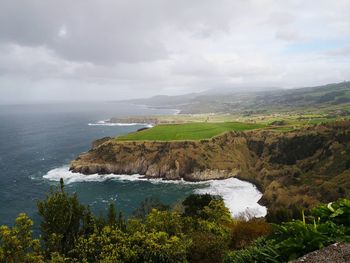 Scenic view of sea and mountains against sky