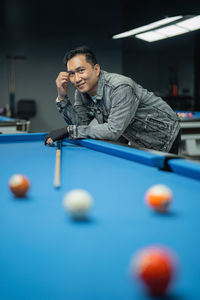 Midsection of man playing pool