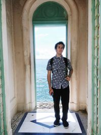 Full length portrait of man standing against building