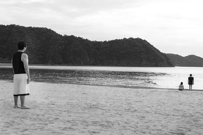 Rear view of people walking on beach