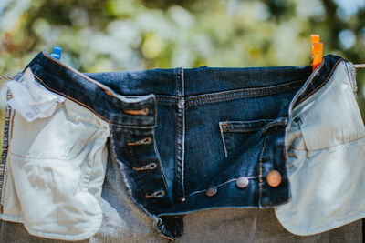 Close-up of jeans hanging on clothesline