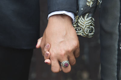 Midsection of couple holding hands
