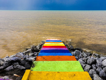 Multi colored umbrella on beach against sky