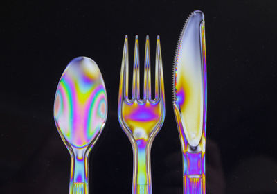 Close-up of multi colored cutlery in darkroom