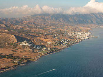 Aerial view of sea and mountains against sky