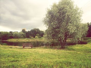 Scenic view of grassy field against cloudy sky