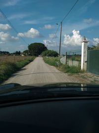 Road against sky seen through car windshield