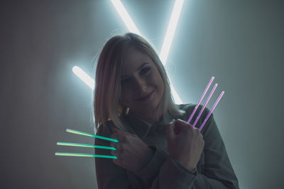 Woman holding colorful equipment at night