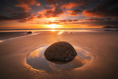 Scenic view of beach against sky during sunset