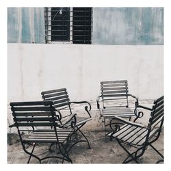 High angle view of empty chairs by wall