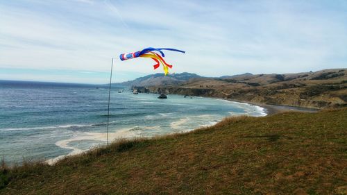 Scenic view from ocean cliff with wind sock against sky