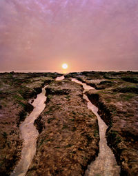 Scenic view of land against sky during sunset