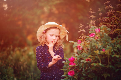 Close-up of cute girl standing by plants at park