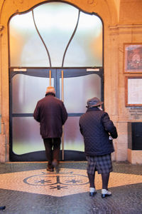 Rear view of man and woman walking in corridor