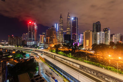 Illuminated buildings in city against sky at night