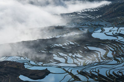 Scenic view of snowcapped mountain against cloudy sky