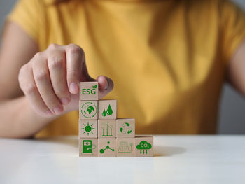 Midsection of man playing with toy blocks on table