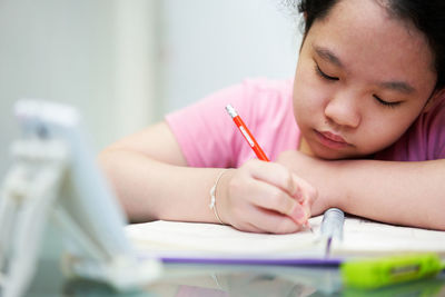 Young woman writing in book