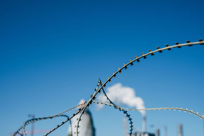 Low angle view of barbed wire against clear sky