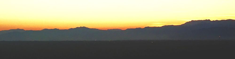 Scenic shot of silhouette mountains against sky at sunset