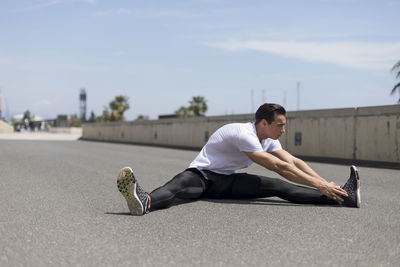 Full length of man stretching on road