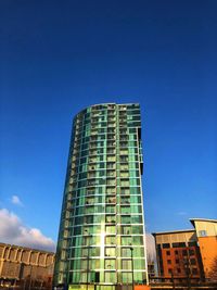 Low angle view of modern building against blue sky