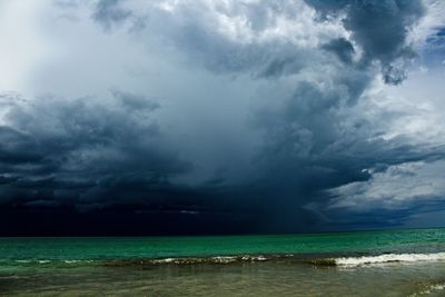 Scenic view of sea against storm clouds