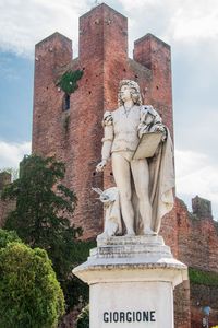 Statue of historical building against cloudy sky