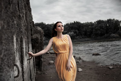 Young woman looking at camera against trees