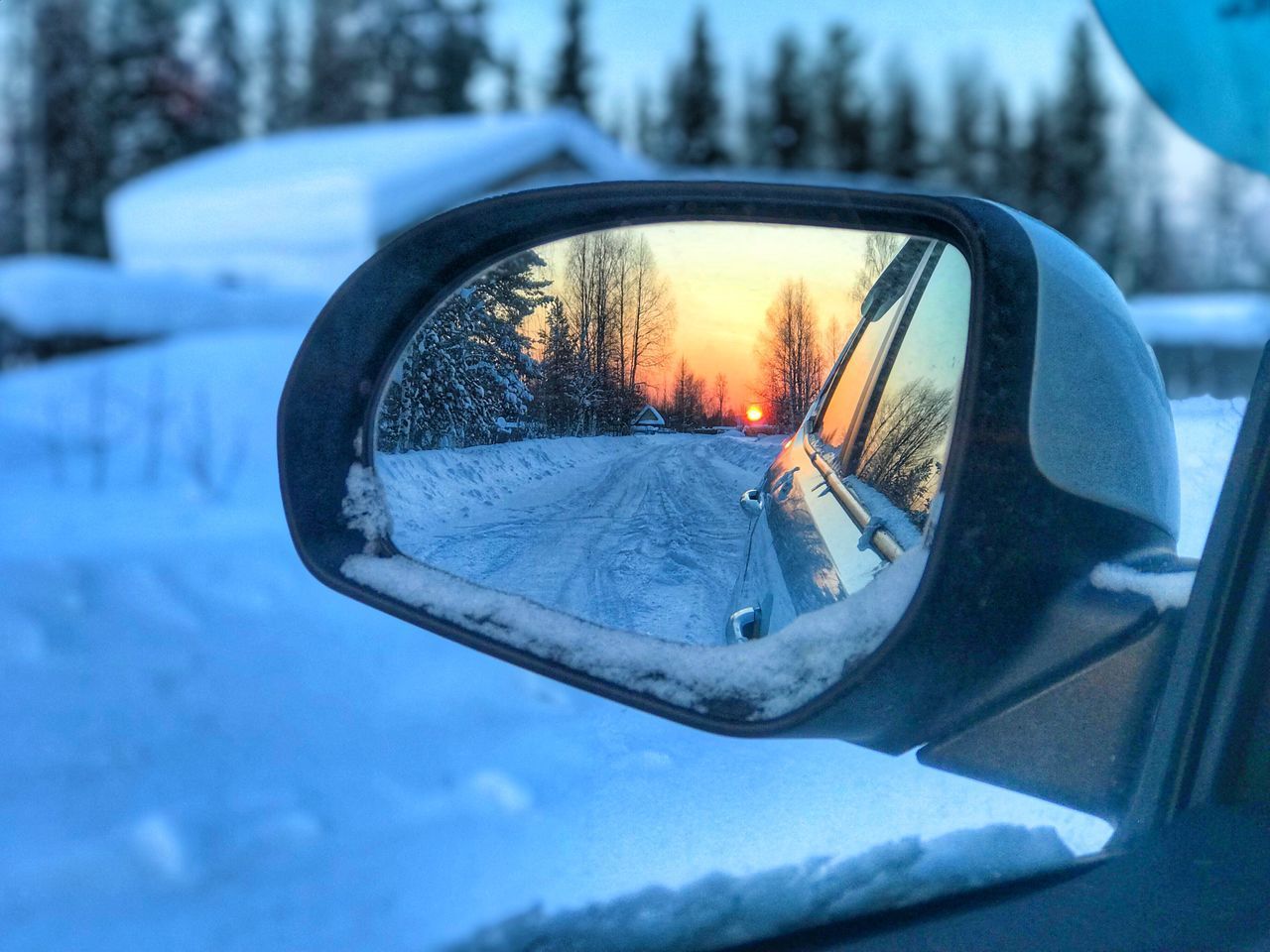 REFLECTION OF SIDE-VIEW MIRROR ON CAR WINDSHIELD DURING WINTER