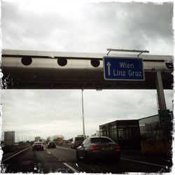 Road sign against cloudy sky