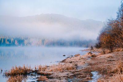 Scenic view of lake against sky during winter