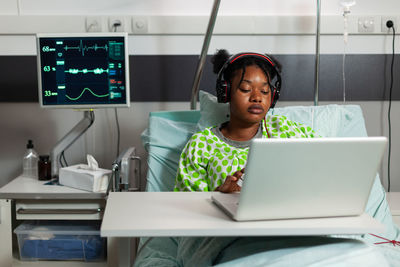 Patient watching movie on laptop in hospital ward