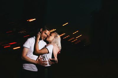 Young couple kissing at night