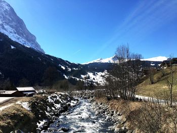 Scenic view of snowcapped mountains against clear blue sky