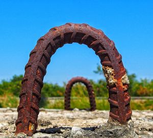 Close-up of rusty metal against clear blue sky